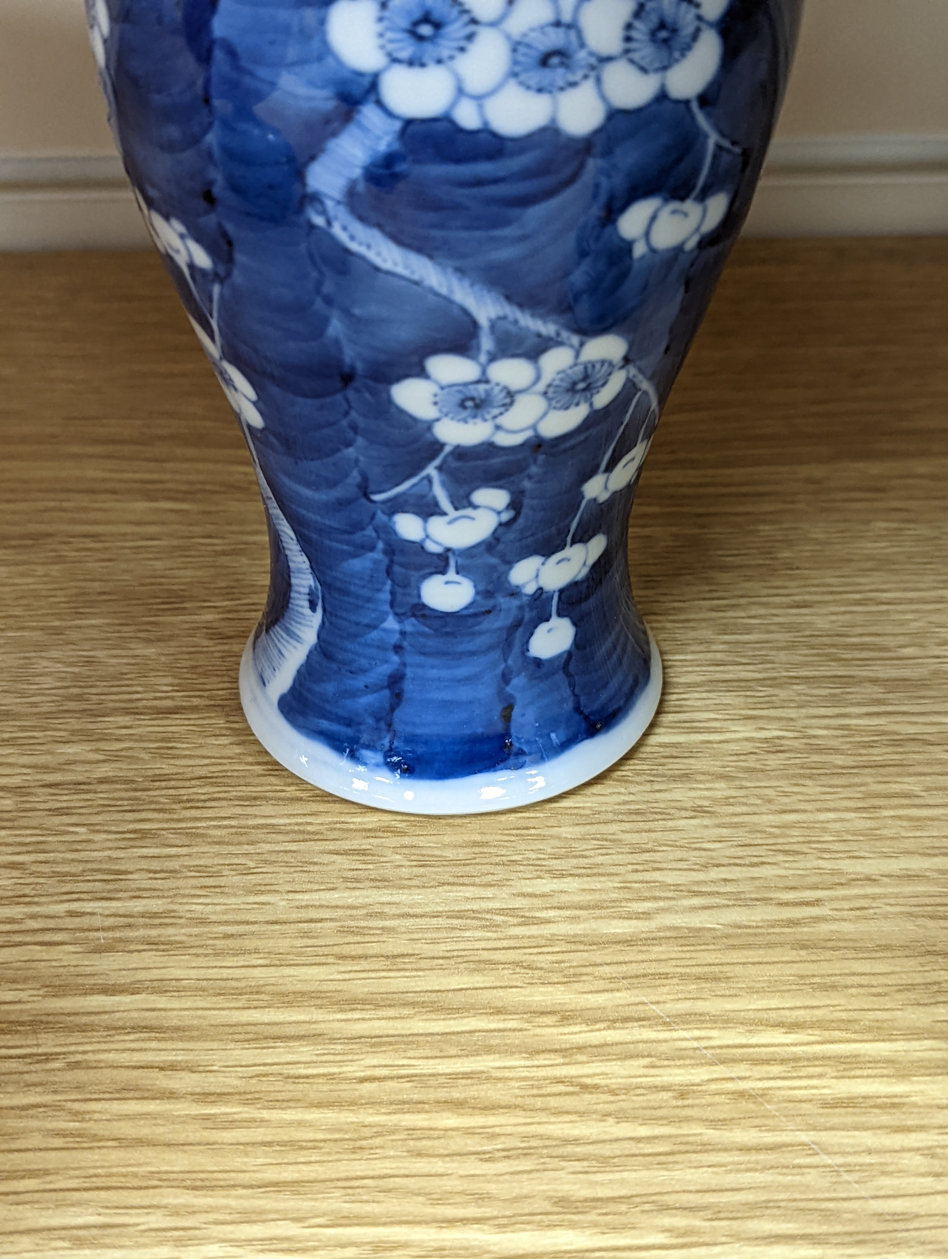 A pair of 19th century Chinese blue and white vases, a prunus vase and cover and a similar jar (4), pair of vases 24 cms high.